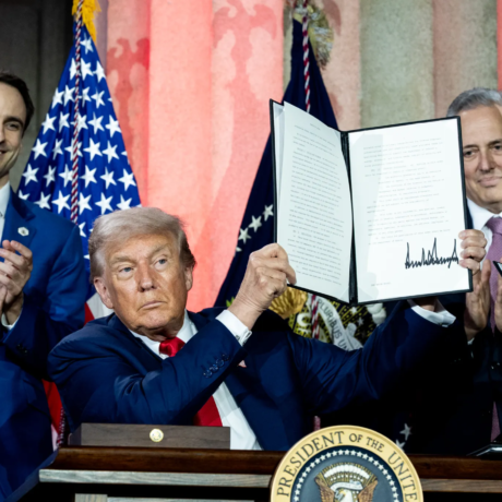 Trump, flanked by Michael Kratsios and David Sacks, displays an executive order at the 23 July 2025 AI Summit in Washington, DC.