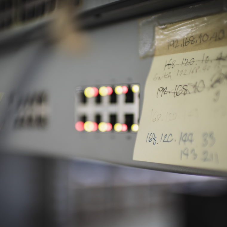 Close up of rack network switch with indication light bokeh and notepad with generic ip address written on it