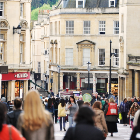BATH, UK - MAY 1, 2014: Crowds of people walk along a busy city centre street. The landmark Somerset UNESCO World Heritage city is popular travel destination with over 4 million visitors per year.