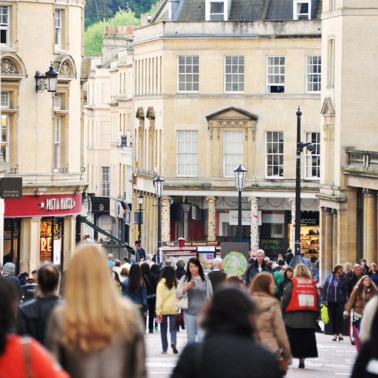 BATH, UK - MAY 1, 2014: Crowds of people walk along a busy city centre street. The landmark Somerset UNESCO World Heritage city is popular travel destination with over 4 million visitors per year.
