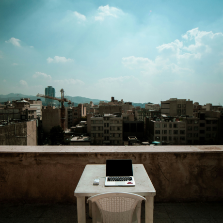 A laptop on a rooftop overlooking Tehran. Photo: Ariyan Dv/Unsplash